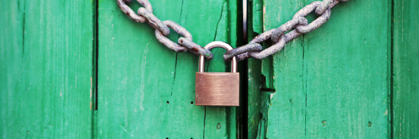 Padlock on chain on green background